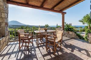 a table and chairs on a patio with a view at Palaeopoli Villas in Avlemonas