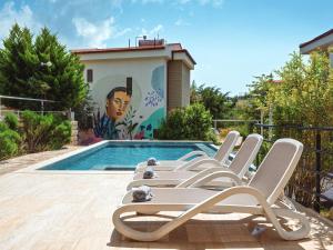 eine Gruppe von Liegestühlen neben einem Schwimmbecken in der Unterkunft Sea Garden Kaş Hotel in Kaş