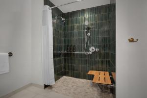 佩索罗伯斯Bellasera Hotel & Suites Paso Robles, Tapestry by Hilton的带淋浴和长凳的浴室