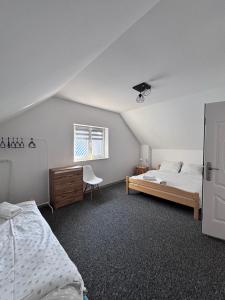 a bedroom with a bed and a desk and a window at Słoneczny Domek in Grywałd