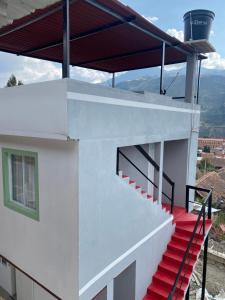 El CocuyGLL HOTEL的房屋的一侧有红色楼梯