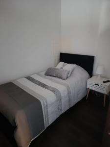 a white bedroom with a bed and a side table at Reis Apartment in Porto