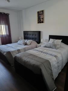 a bedroom with two beds and a window at Reis Apartment in Porto