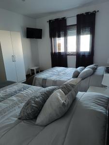 a bedroom with two beds with pillows on them at Reis Apartment in Porto