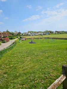 un parque con parque infantil en medio de un campo en 1 Bed Flat in Winchelsea Beach, en Winchelsea