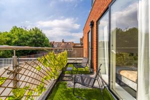 a balcony with two chairs and glass doors at free parking,Top location, Shops in Edgware