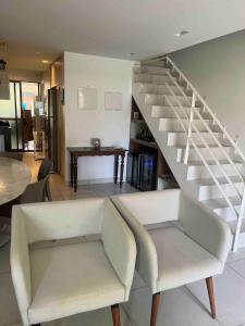 a living room with a staircase and a chair at Complete beach house! in Cabedelo