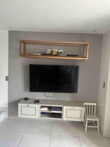 a living room with a flat screen tv on a wall at Complete beach house! in Cabedelo
