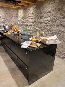 a kitchen with a black counter top in a stone wall at Boutiquehotel Rattenberg in Rattenberg