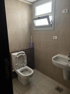 a bathroom with a toilet and a sink at Golf Porto marina in El Alamein +3 photos