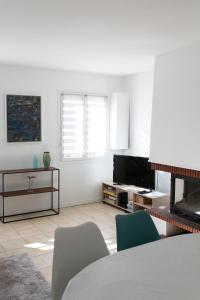a white living room with a table and chairs at La Montpensier - maison dans le centre ville d'Eu in Eu