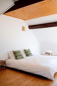 a bed in a room with a wooden ceiling at La Montpensier - maison dans le centre ville d'Eu in Eu +31 photos