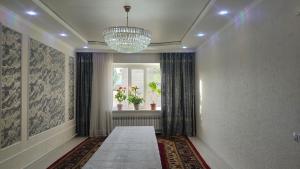 a hallway with a chandelier and a window at Bayel Guest house in Kochkorka +16 photos