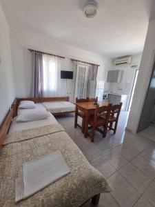 a room with two beds and a table and a kitchen at Sun Ray Sivota 7 in Syvota
