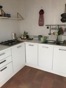 a kitchen with white cabinets and a stove top oven at Delizioso appartamento nel centro storico in Mattinata
