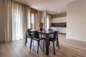 a dining room with a black table and chairs at IdealHome Suite in Padova