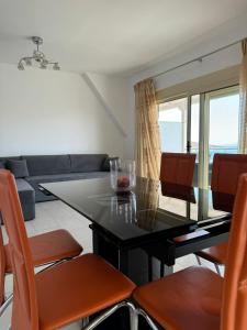 a living room with a black table and orange chairs at Michal's Apartment in Sarandë +40 photos