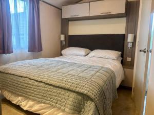 HolcotにあるCaravan in Holcot - Sleeps 6 - Pet Friendlyの大きなヘッドボード付きの大きなベッドのある寝室