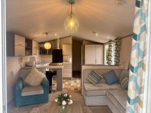 a living room with two couches and a kitchen at Caravan in Holcot - Sleeps 6 - Maximum 6 people - Maximum 4 adults per booking -Pet Friendly in Holcot