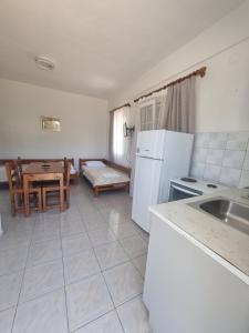 a kitchen with white appliances and a table with a couch at Sun Ray Sivota 7 in Syvota +16 photos