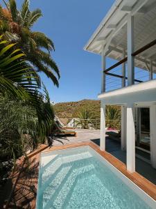 a swimming pool in front of a house at Pearl's Roc Villa in Gustavia