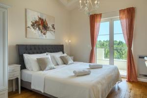 a bedroom with a large white bed with a window at Villa Vita by Villas Guide in Vranići +34 photos
