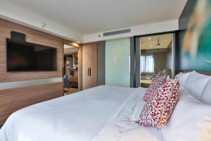 een slaapkamer met een groot wit bed met kussens bij Novotel Sorocaba in Sorocaba +94 foto's