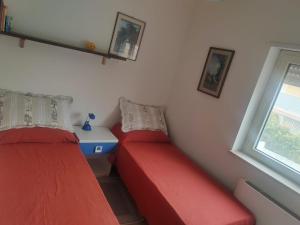 two red beds in a room with a window at Villa Brenda in Pizzo +11 photos