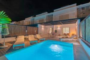 a swimming pool on a patio with chairs and a house at Villa Serena Blanca by Villalia Luxury Oasis & Private Pool in Playa Blanca