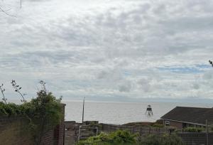 a person standing in the water on a beach at Lighthouse Lodge in Harwich
