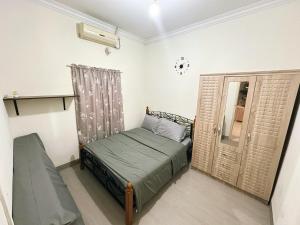 a small bedroom with a bed and a window at Palm Beach Stay Near to Grand Batam Penuin Nagoya Hill in Nagoya