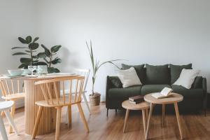 a living room with a green couch and tables at L'escapade appartement 4 pers in Ouistreham