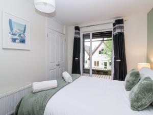 a bedroom with a large white bed and a window at 23 Valley Lodge in Callington
