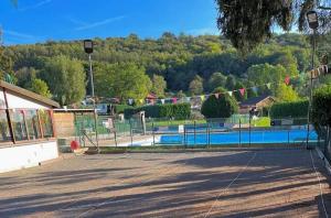 a swimming pool with a fence with flags on it at Bungalow in Yvoir +5 photos