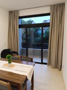 a dining room with a table and a large window at Temporarios Moritan 1A in Posadas +6 photos