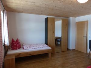 een slaapkamer met een bed en een houten plafond bij Haus Schwärzler in Stiefenhofen