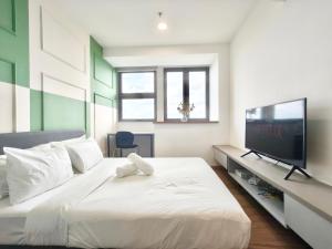 a bedroom with a large bed and a flat screen tv at Riveria City KL Sentral by Guestsupply in Kuala Lumpur