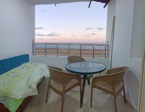 ein Schlafzimmer mit Tisch und Stühlen und Blick auf das Meer in der Unterkunft Furnished Apartment - Beach view "Nearest Beach 2 minutes walking" - Abo keer - Alexandria - Egypt in Abū Qīr