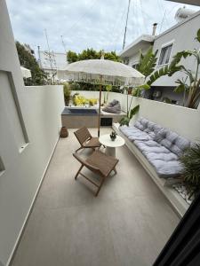 an outdoor patio with a couch and an umbrella at erasmia luxury suite in Georgioupolis