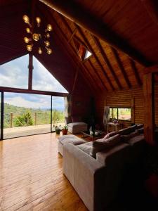a large living room with couches and a large window at La Bambina Cabaña Glamping in Guarne