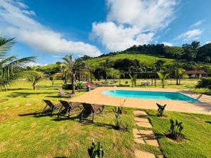 a resort with a swimming pool and two chairs at Paraíso Capitólio "A Pousada da Dona Perpetua" in Capitólio