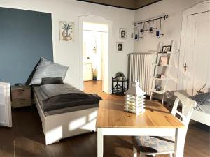 a bedroom with a bed and a wooden table at Sinos Pension in Elmshorn