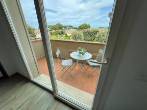 a sliding glass door with a table and chairs on a balcony at Residence San Francesco in Tirrenia