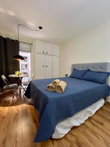 une chambre avec un lit bleu avec des serviettes dessus dans l'établissement Ap Smart Bosque, à Campinas
