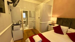 a bedroom with a bed and a bathroom with a sink at Classic Hyde Park Hotel in London