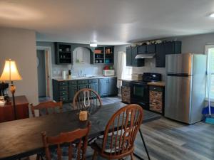 a kitchen with a wooden table and a refrigerator at Buffalo House St Joe in Saint Joe