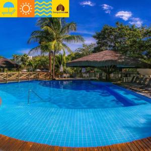 a large blue swimming pool with a palm tree at Suites Le Jardin Caldas Novas - Temporada in Caldas Novas