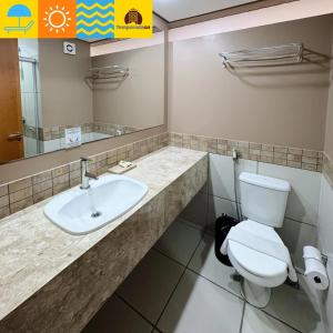 a bathroom with a toilet and a sink at Suites Le Jardin Caldas Novas - Temporada in Caldas Novas
