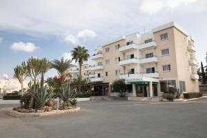 ein großes weißes Gebäude mit Palmen davor in der Unterkunft DebbieXenia Hotel Apartments in Protaras