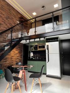 una cucina con scala, tavolo e sedie di Loft Sonho de Beija ad Araxá
